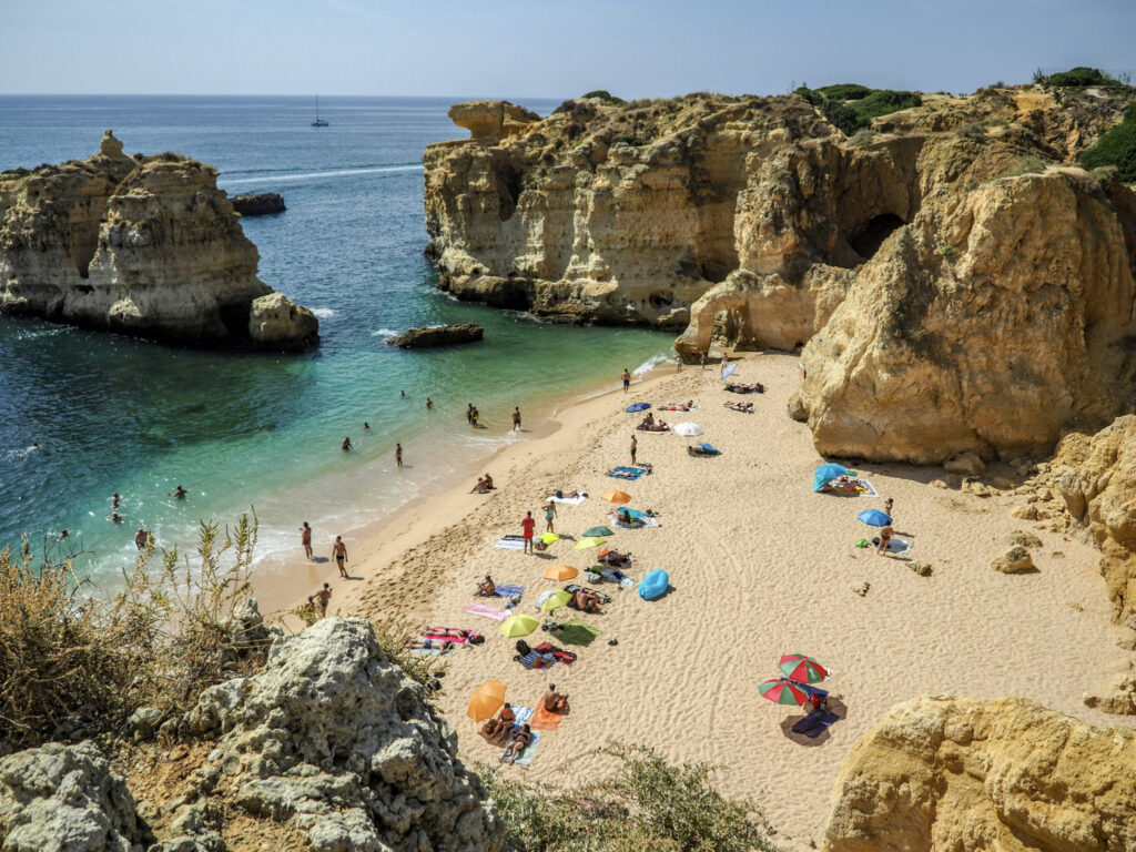 10 Trendy Beaches in Europe for 2026 Golden limestone cliffs and arches at Praia da Marinha, Algarve, Portugal