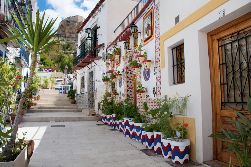 Whitewashed houses and potted flowers on steps in Alicante old town