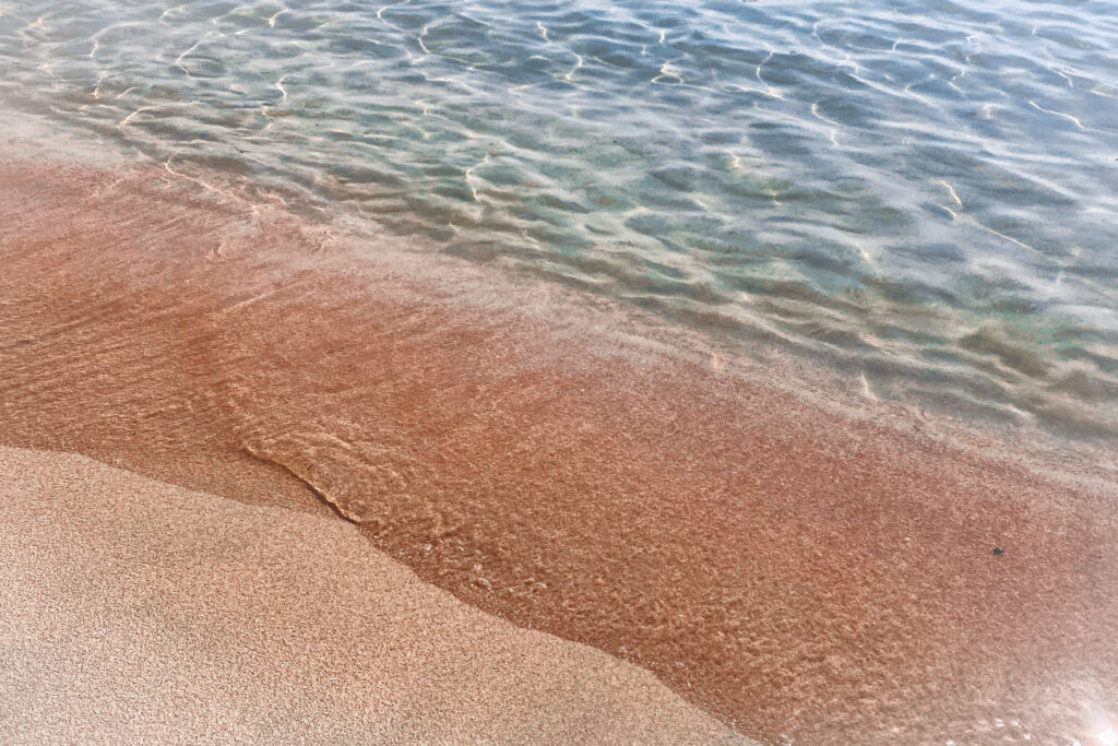Best 10 Beaches in Crete, Greece Close-up of Elafonisi's pink-tinted sand meeting clear water
