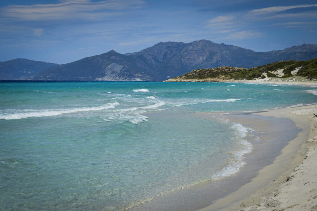 Best 10 Beaches in Crete, Greece Waves washing onto sand with mountains behind at Kedrodasos Beach, Crete