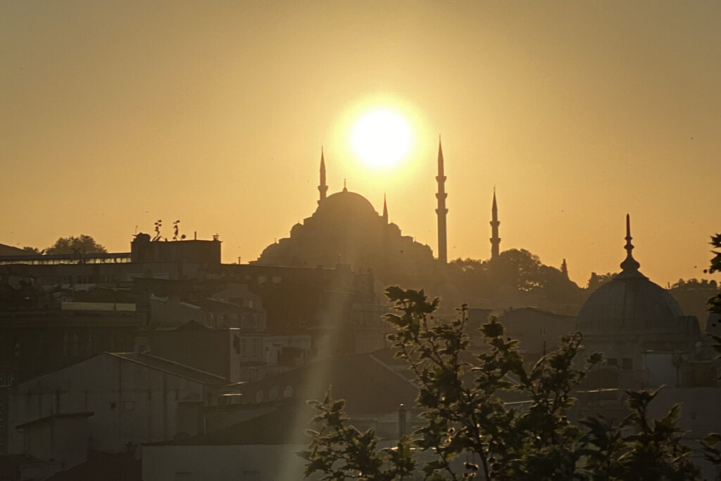 3 Days in Istanbul, Turkey The sun setting directly behind the domes and minarets of Suleymaniye Mosque in Istanbul Turkey