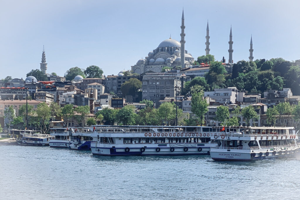 3 Days in Istanbul, Turkey Bosphorus tour boats docked at Eminonu with Suleymaniye Mosque on the hillside in Istanbul Turkey