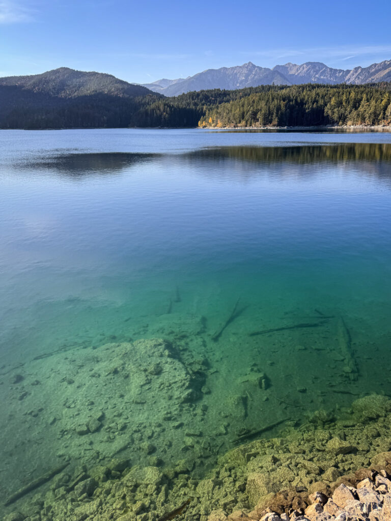 3 Days in Bavaria, Germany Clear turquoise waters of Lake Eibsee reflecting evergreen forests and distant mountains in Bavaria Germany