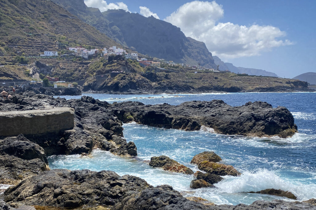Top 10 Things to Do in Tenerife Natural volcanic rock pools at El Caletón with Garachico town in the background, Tenerife