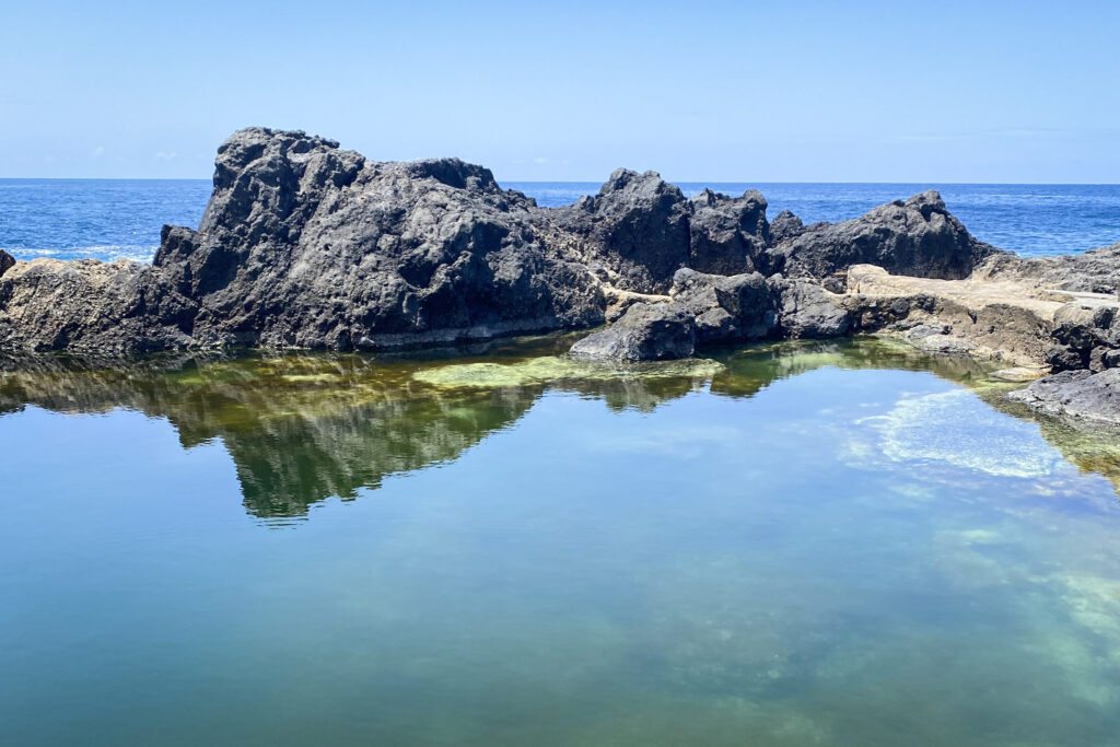 Top 10 Things to Do in Tenerife Calm natural rock pool reflecting volcanic rocks at El Caletón, Garachico, Tenerife