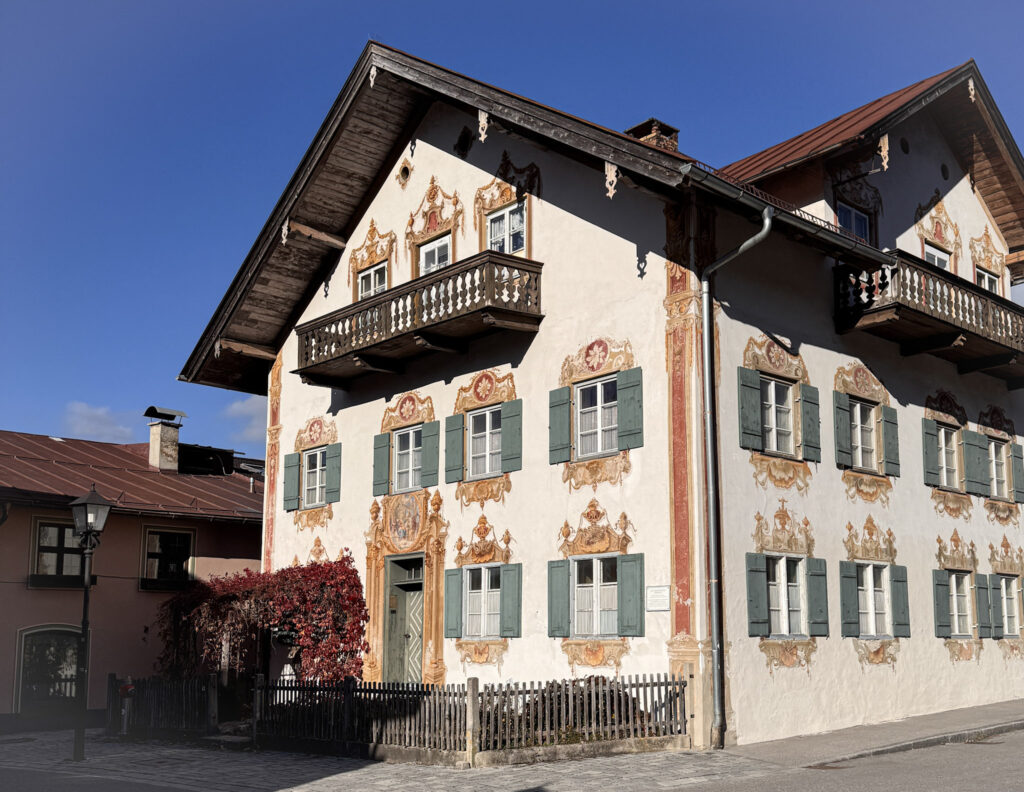 3 Days in Bavaria, Germany Traditional building featuring ornate Lüftlmalerei facade paintings on a sunny street in Oberammergau Germany