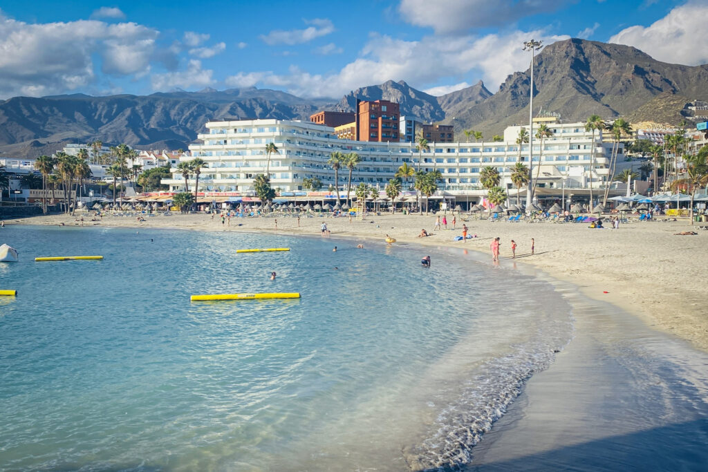 Top 10 Things to Do in Tenerife Playa La Pinta beach with resort hotels and mountains, Puerto Colón, Tenerife