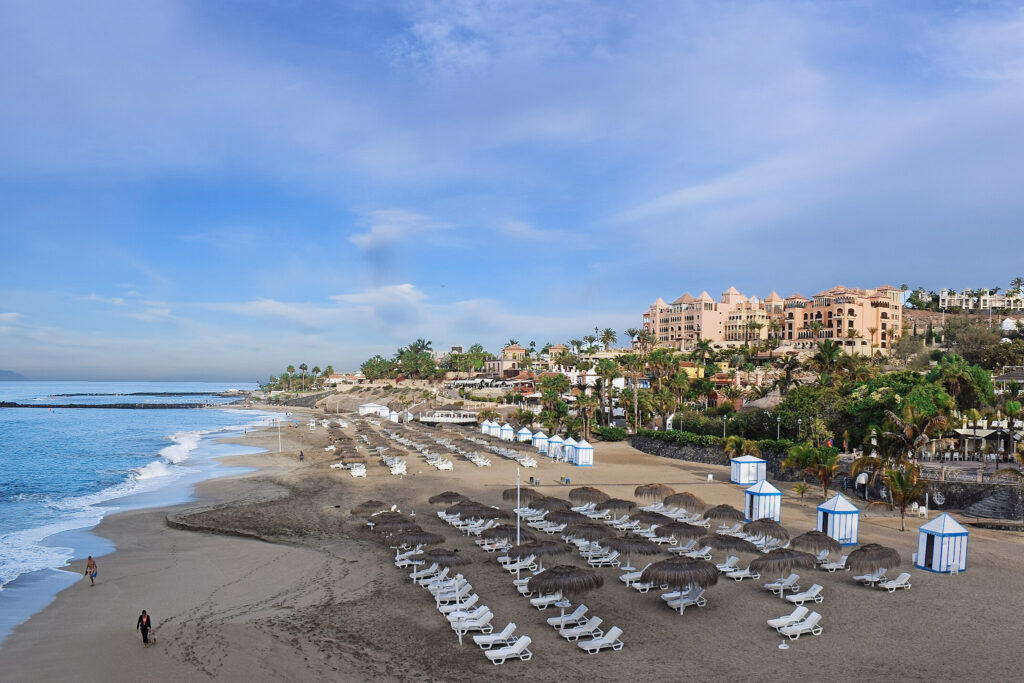 Top 10 Beaches in Tenerife Premium sun loungers and thatched umbrellas on the golden sands of Playa del Duque beach in southern Tenerife