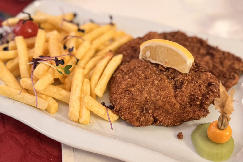 3 Days in Bavaria, Germany Crispy golden German Schnitzel served with a lemon wedge and french fries on a long plate