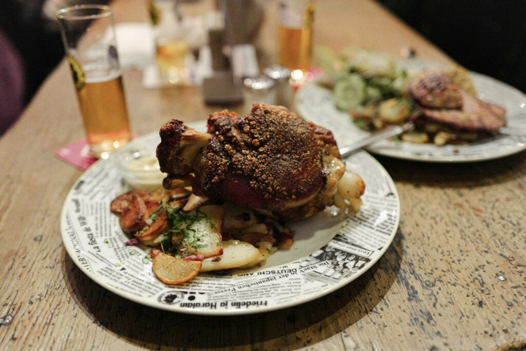 3 Days in Bavaria, Germany Traditional Bavarian Schweinshaxe roasted pork knuckle served with fried potatoes and beer in Germany