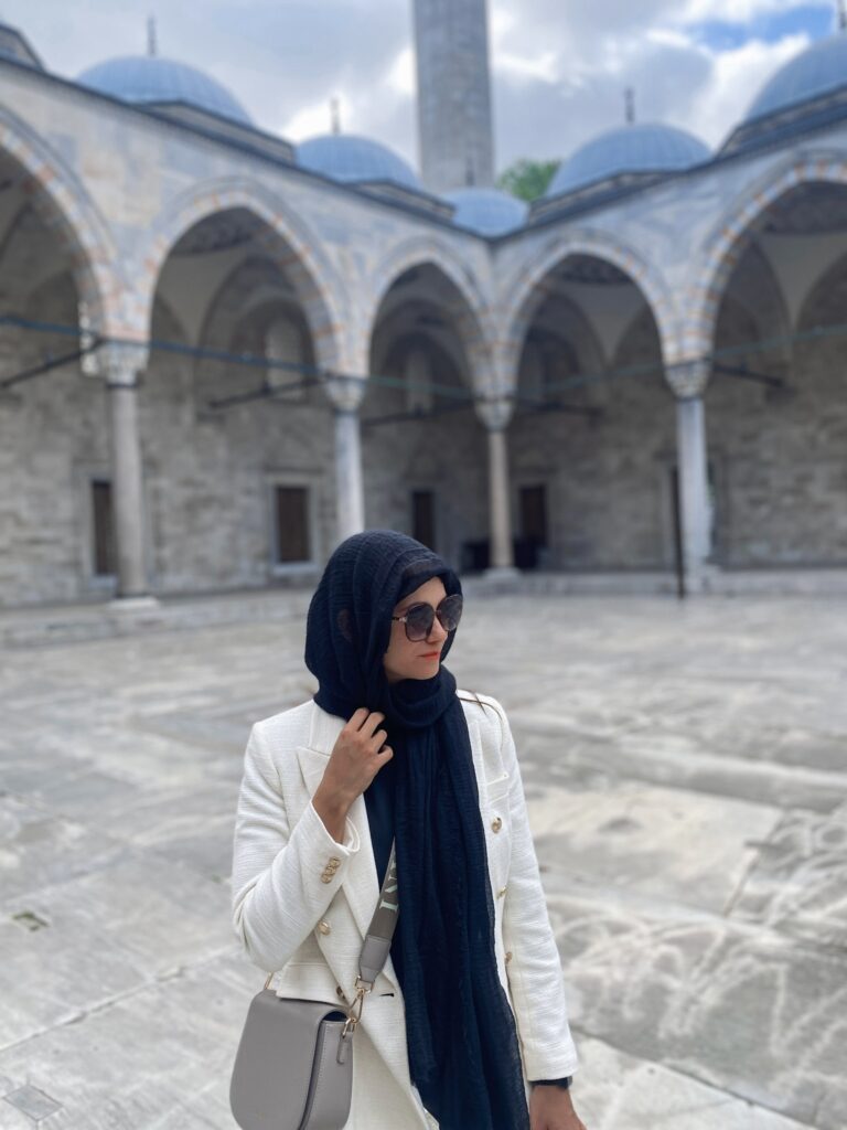 3 Days in Istanbul, Turkey Jet Lag Jelly creator wearing a white blazer and black headscarf dress code inside Suleymaniye Mosque courtyard