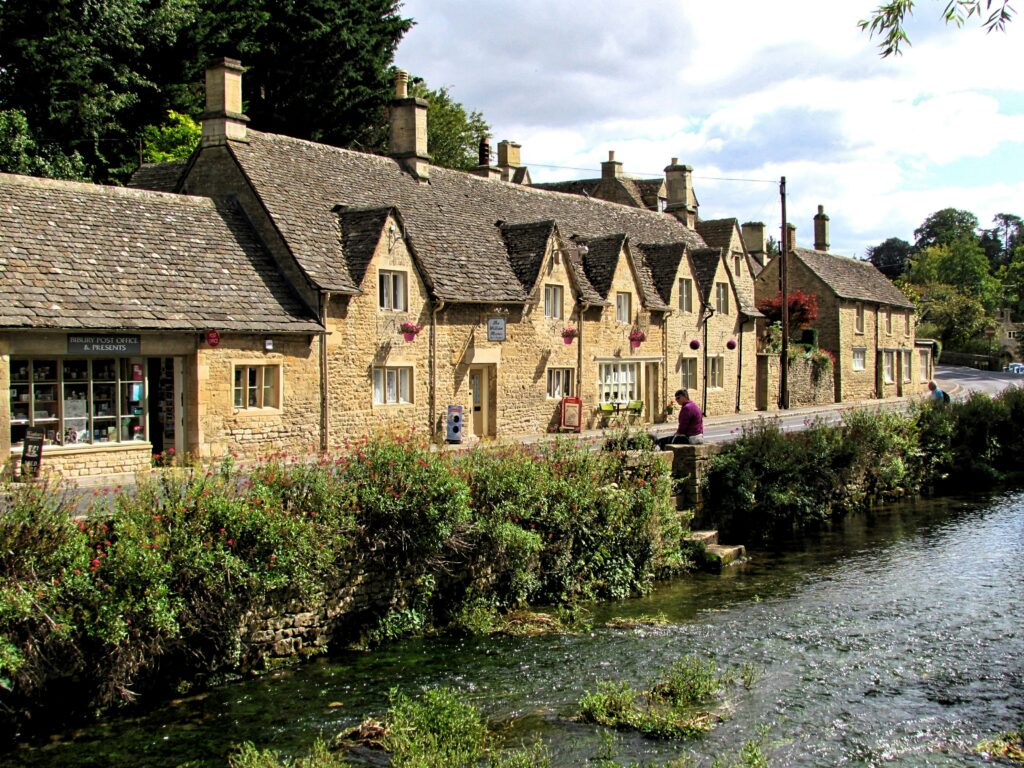 Top 5 Villages in the Cotswolds The historic Bibury Post Office and traditional limestone buildings sitting alongside the scenic River Coln in the Cotswolds.