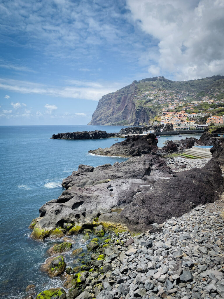 Madeira Travel Guide Volcanic rock coastline and distant sea cliffs in Câmara de Lobos, Madeira.