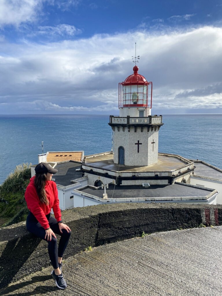 Top Things to Do in São Miguel, Azores Traveler exploring the rugged coast and Arnel Lighthouse in Nordeste during a São Miguel road trip.