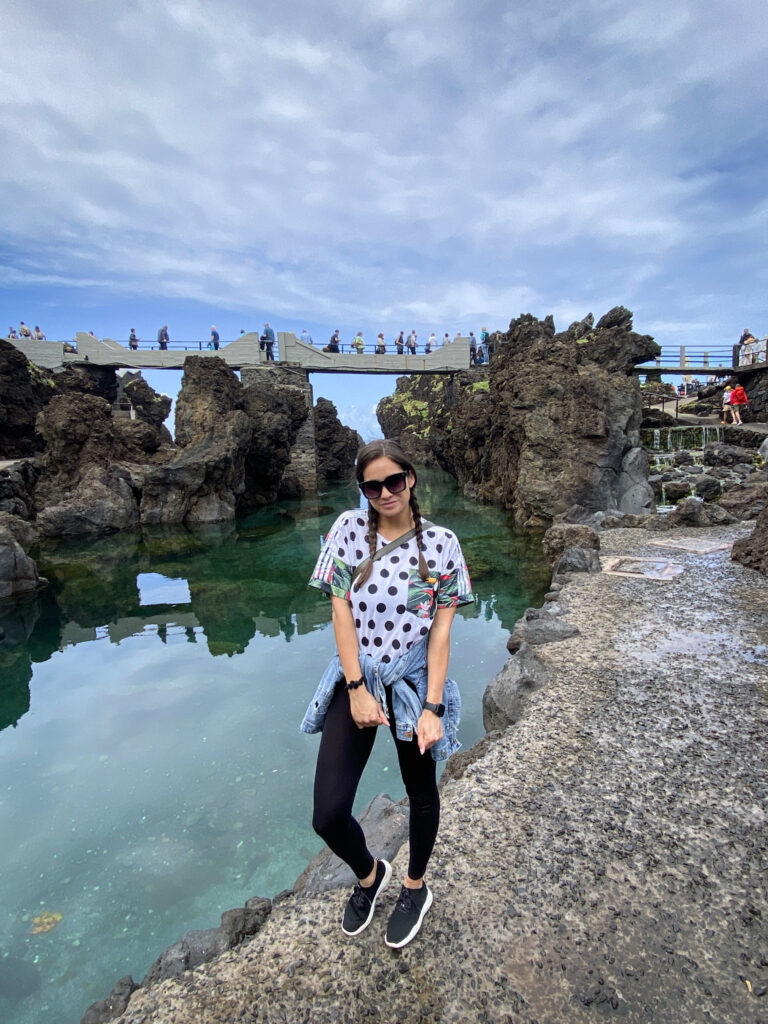 Madeira Travel Guide Traveler posing at the Porto Moniz volcanic natural pools in Madeira.