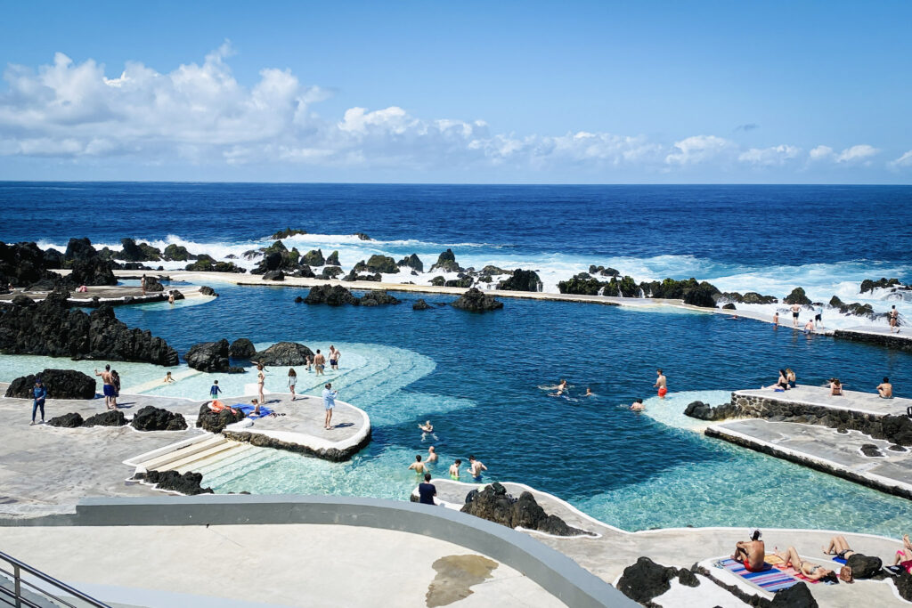 Madeira Travel Guide Sunny panoramic view of the volcanic natural pools in Porto Moniz, Madeira.