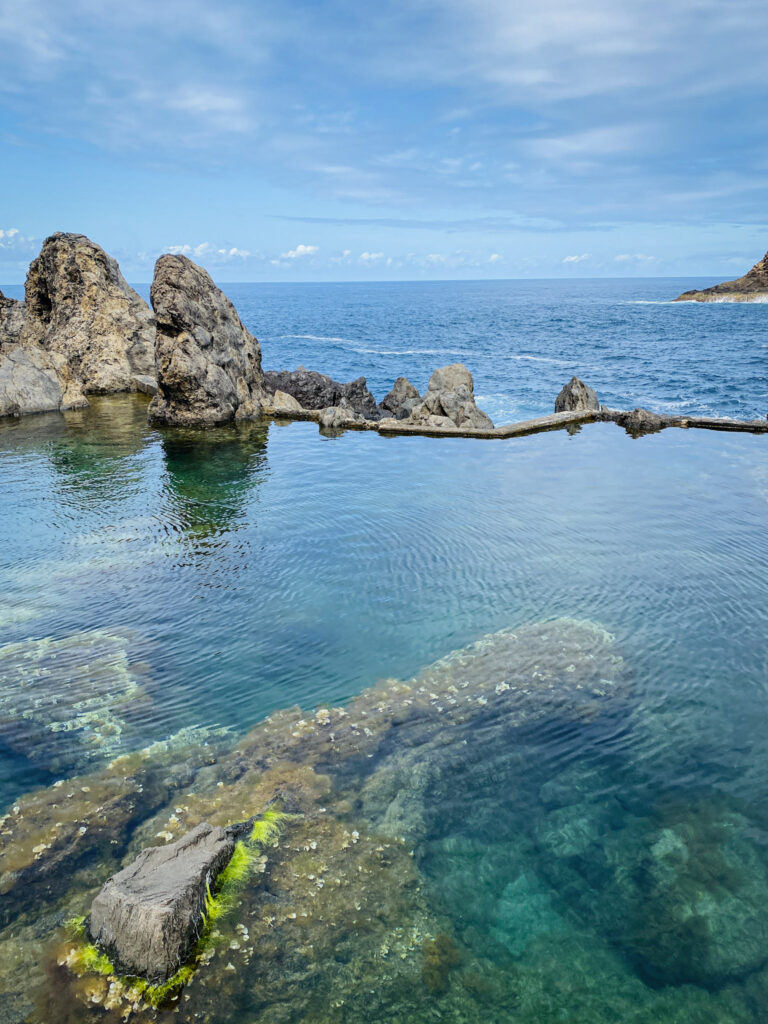 Madeira Travel Guide Clear, turquoise natural volcanic tide pool overlooking the deep blue Atlantic Ocean in Seixal, Madeira.