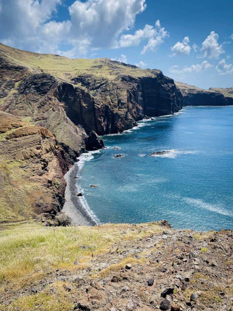 Madeira Travel Guide Dramatic layered volcanic cliffs overlooking a bright blue ocean cove along the PR8 Vereda da Ponta de São Lourenço trail in Madeira